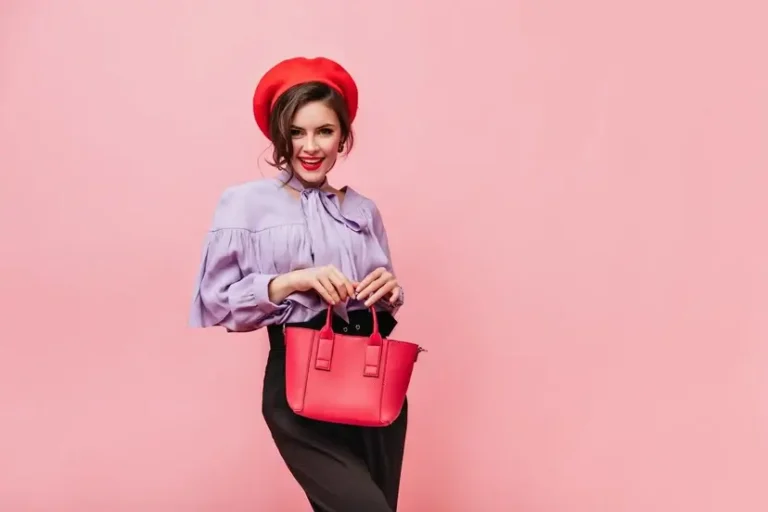 Uma mulher segurando uma bolsa feminina vermelha.